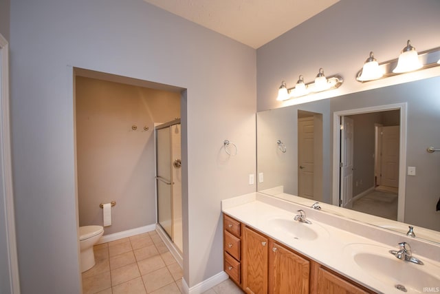 bathroom featuring toilet, vanity, a shower with door, and tile patterned floors