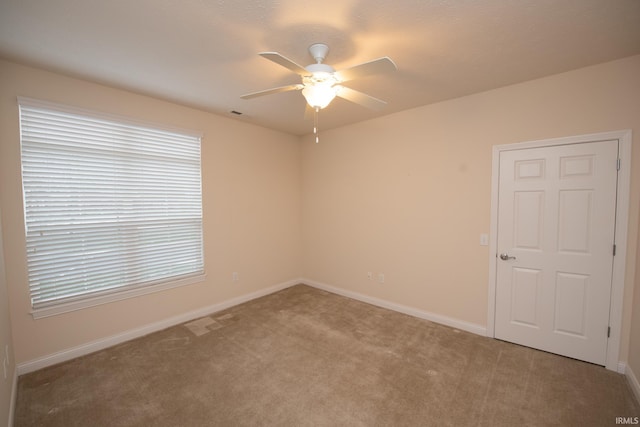 spare room with carpet floors and ceiling fan