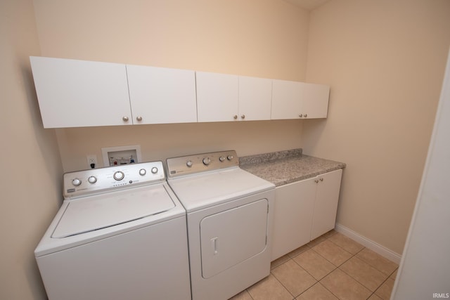 laundry room featuring light tile patterned floors, independent washer and dryer, and cabinets