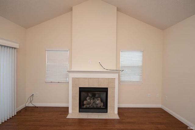 unfurnished living room with lofted ceiling, dark hardwood / wood-style floors, and a tile fireplace