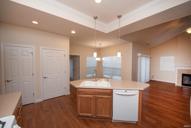 kitchen with white dishwasher, a kitchen island with sink, a tile fireplace, and sink