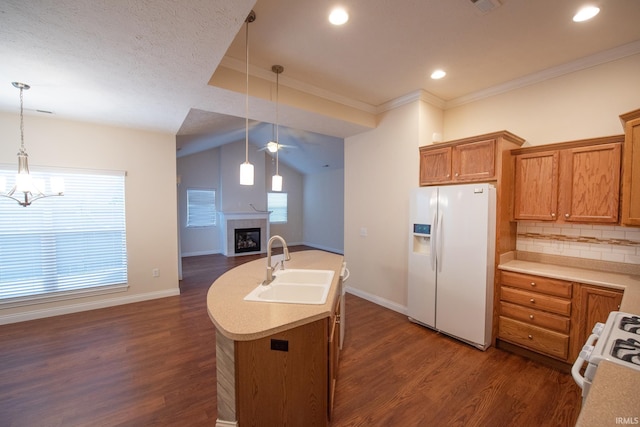 kitchen featuring pendant lighting, backsplash, white appliances, and sink