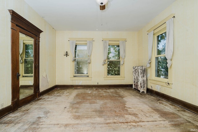 spare room featuring ceiling fan and radiator