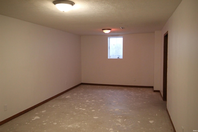 unfurnished room with concrete flooring and a textured ceiling