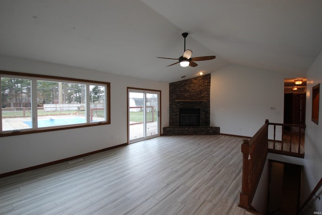 unfurnished living room with a fireplace, light wood-type flooring, vaulted ceiling, and ceiling fan