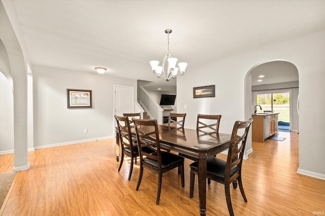 dining room with light hardwood / wood-style flooring, a notable chandelier, and sink