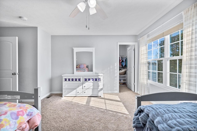 carpeted bedroom featuring ceiling fan, a textured ceiling, and a closet