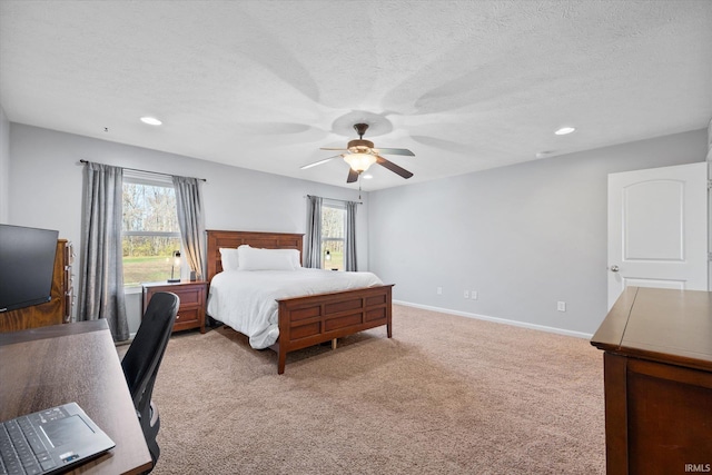 bedroom with ceiling fan, light carpet, and multiple windows