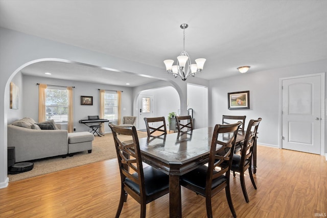 dining area featuring light wood-type flooring and a notable chandelier