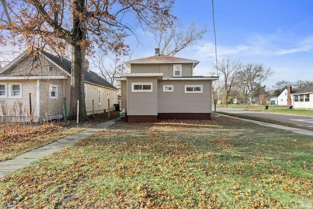 back of house featuring a lawn