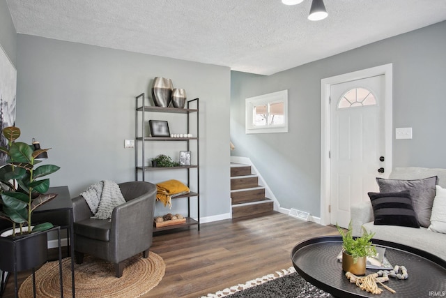 living room featuring dark hardwood / wood-style flooring and a textured ceiling