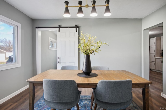 dining room featuring a barn door and dark wood-type flooring