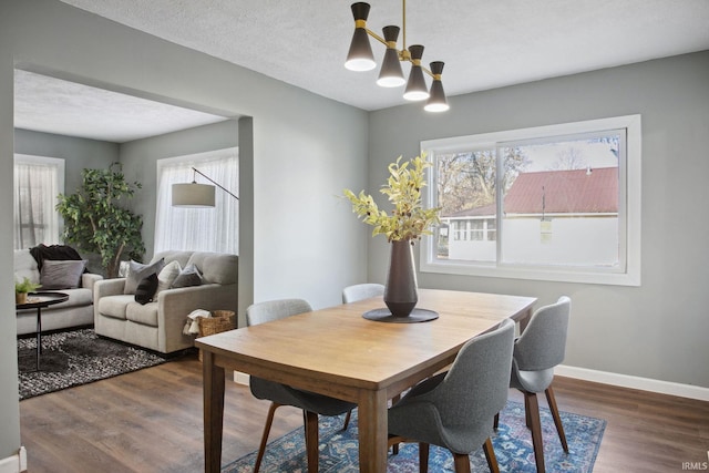 dining area with a textured ceiling and dark hardwood / wood-style floors