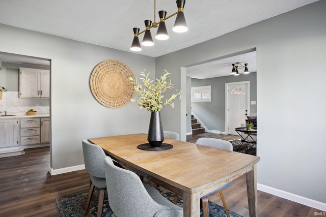 dining area with a textured ceiling and dark wood-type flooring