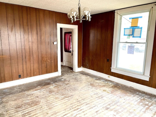 empty room with wooden walls and a chandelier