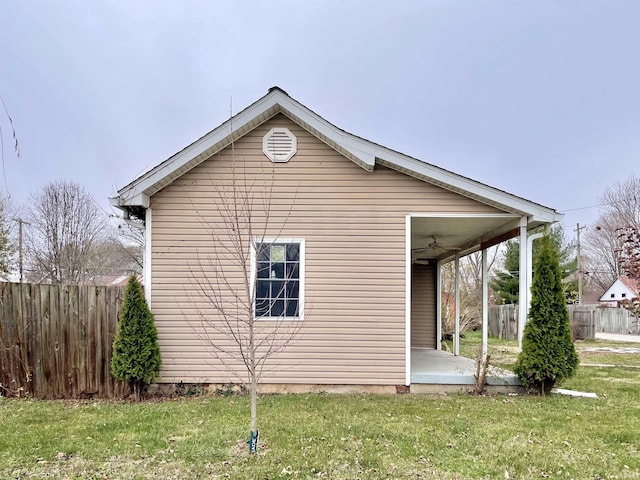 view of side of property featuring a lawn and ceiling fan