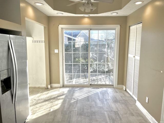 doorway featuring a textured ceiling, light hardwood / wood-style floors, and ceiling fan