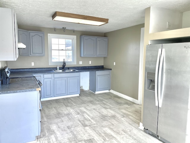 kitchen featuring a textured ceiling, light hardwood / wood-style floors, sink, and stainless steel appliances