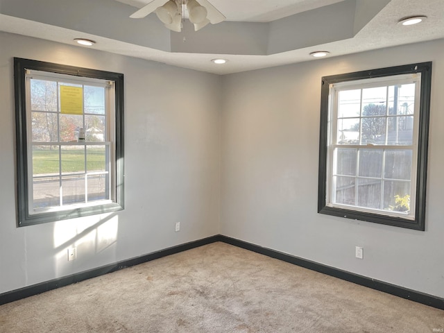 carpeted empty room featuring plenty of natural light, ceiling fan, and a textured ceiling