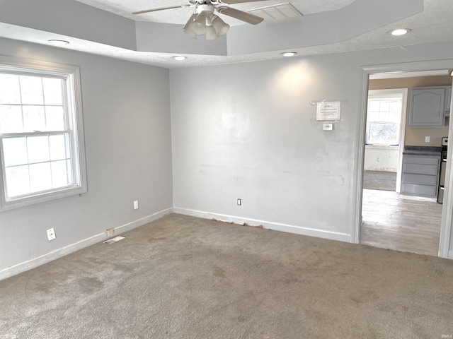 spare room with ceiling fan, carpet, and a textured ceiling