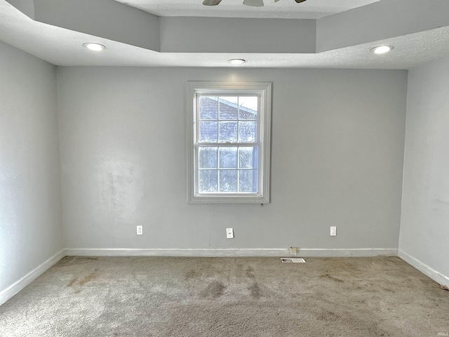 carpeted spare room with a textured ceiling and ceiling fan