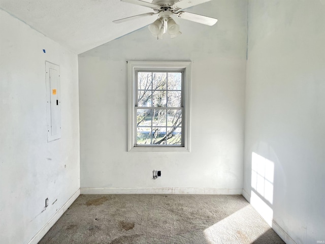 empty room featuring ceiling fan, electric panel, a textured ceiling, lofted ceiling, and carpet