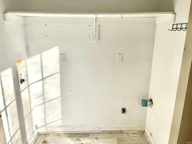 laundry room with electric dryer hookup and light wood-type flooring