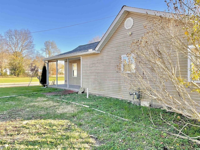 view of side of home with a yard