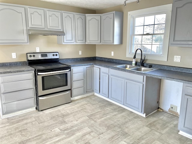 kitchen featuring electric range, sink, and a textured ceiling