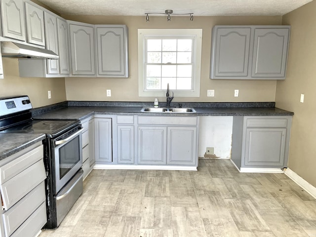 kitchen featuring electric stove, sink, a textured ceiling, and light wood-type flooring