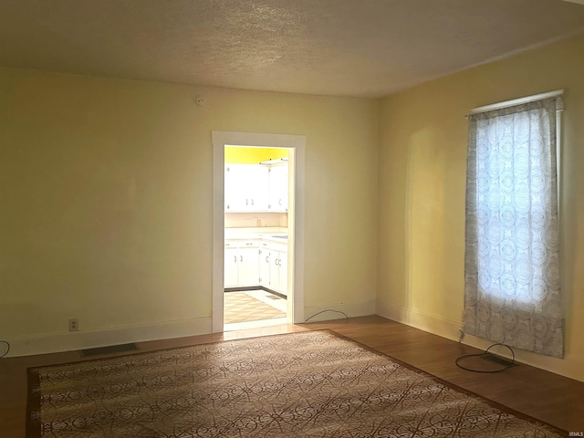 unfurnished room featuring a textured ceiling and hardwood / wood-style flooring