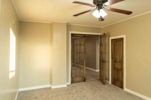 unfurnished room featuring crown molding, ceiling fan, and light colored carpet