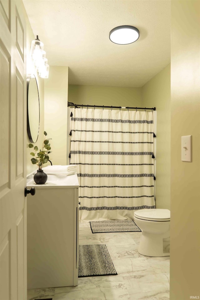 bathroom with vanity, curtained shower, and toilet