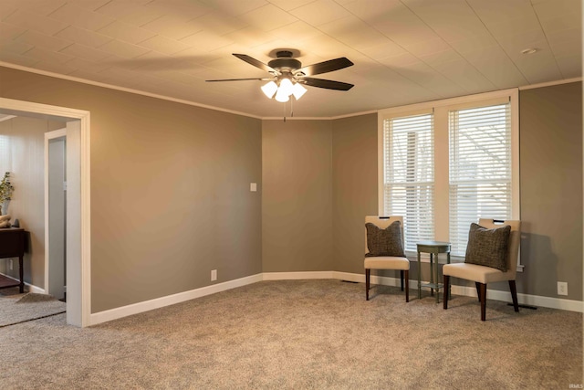 living area with ceiling fan, carpet floors, and ornamental molding