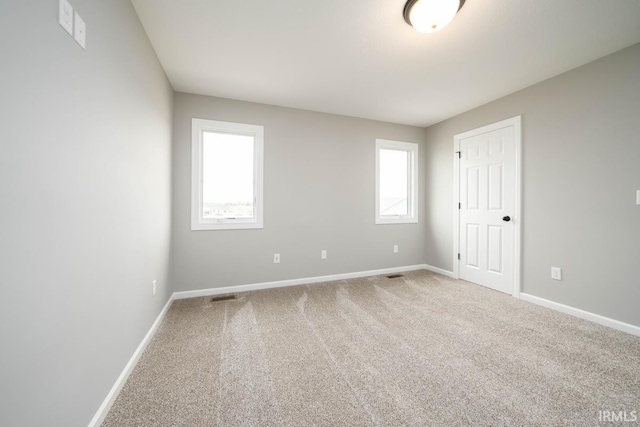 carpeted spare room featuring a wealth of natural light