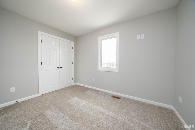 unfurnished bedroom featuring a closet and carpet floors