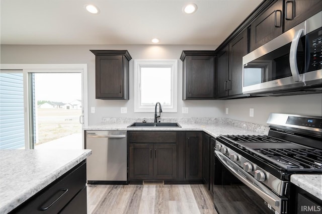 kitchen with light hardwood / wood-style floors, sink, stainless steel appliances, and a wealth of natural light