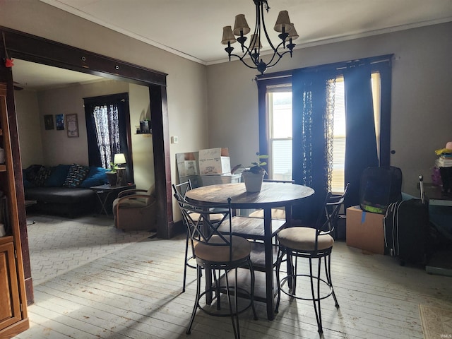 dining space featuring crown molding, a notable chandelier, and light wood-type flooring