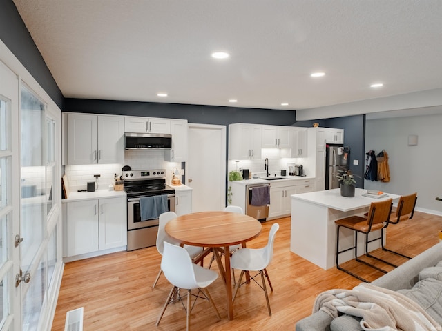 kitchen featuring white cabinetry, sink, light wood-type flooring, and appliances with stainless steel finishes