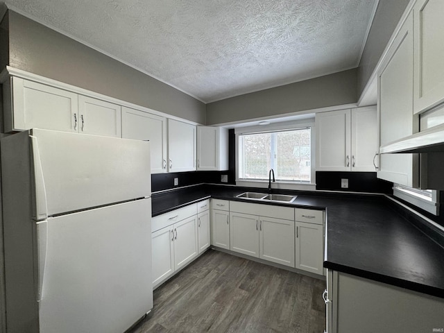 kitchen with dark hardwood / wood-style flooring, white fridge, white cabinetry, and sink