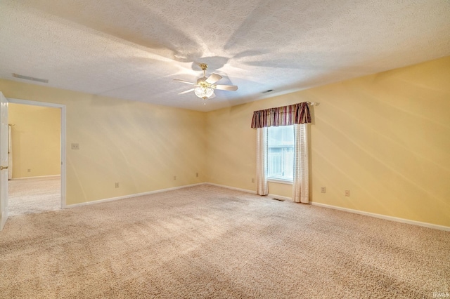 carpeted spare room with ceiling fan and a textured ceiling