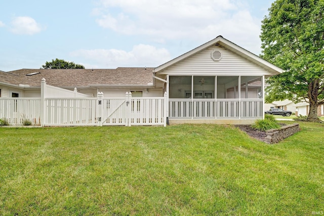 rear view of property with a sunroom and a yard