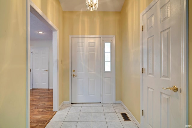 entryway with an inviting chandelier and light hardwood / wood-style flooring