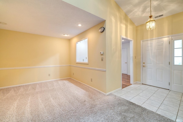 carpeted foyer featuring an inviting chandelier