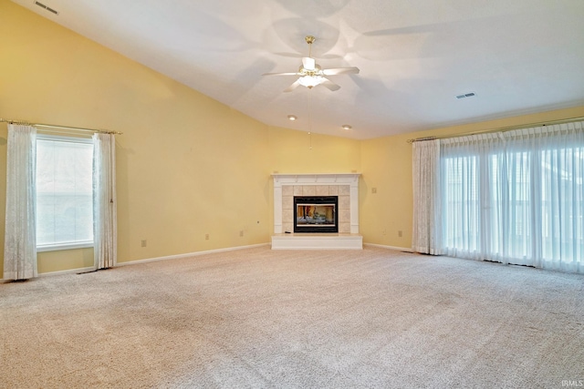 unfurnished living room featuring ceiling fan, a fireplace, lofted ceiling, and light carpet