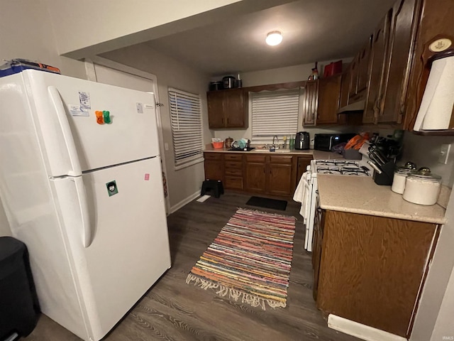 kitchen with dark hardwood / wood-style flooring and white appliances