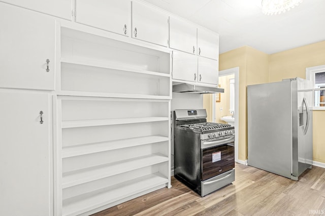 kitchen with appliances with stainless steel finishes, light hardwood / wood-style floors, and white cabinetry