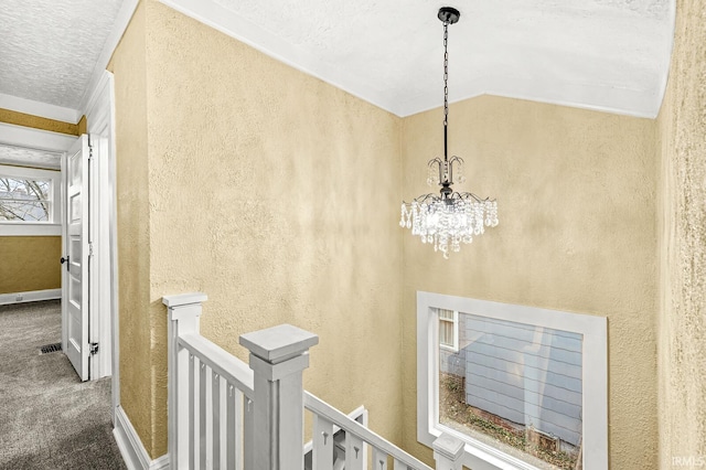 interior space with crown molding, carpet, vaulted ceiling, and an inviting chandelier