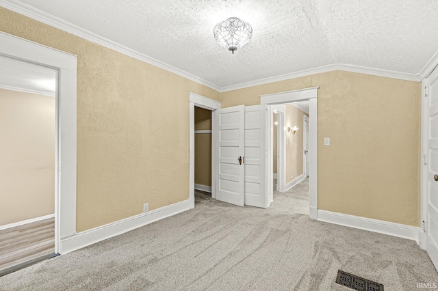 unfurnished bedroom featuring light carpet, a textured ceiling, and crown molding