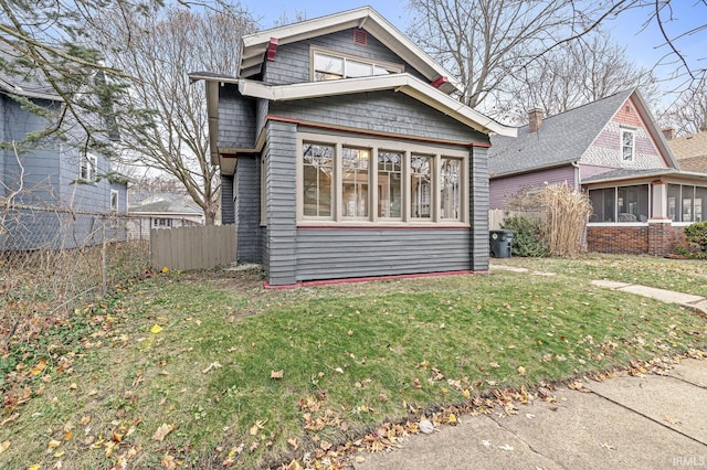 view of front facade with a sunroom and a front lawn